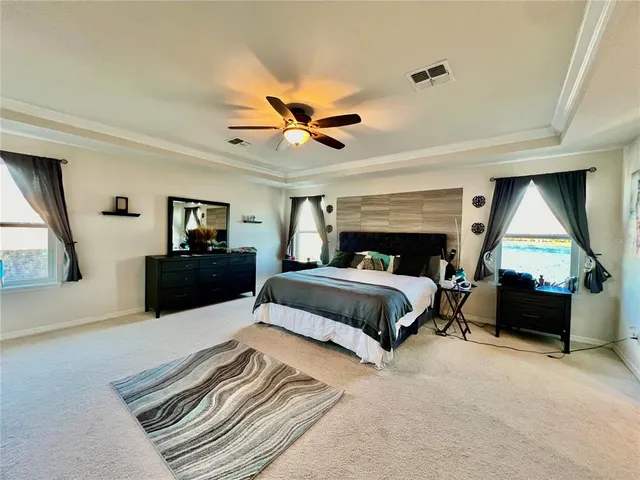 a spacious bedroom with a bed and a chandelier