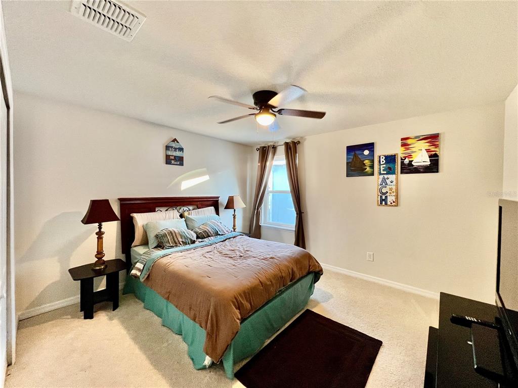 14112 Poke Ridge Drive Riverview, FL 33579 - Photo 27 of 46 a bedroom with a bed and a chandelier