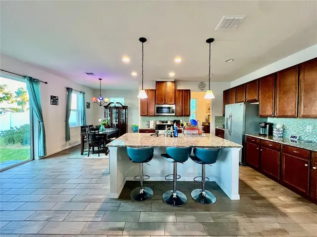 a large kitchen with a table and chairs