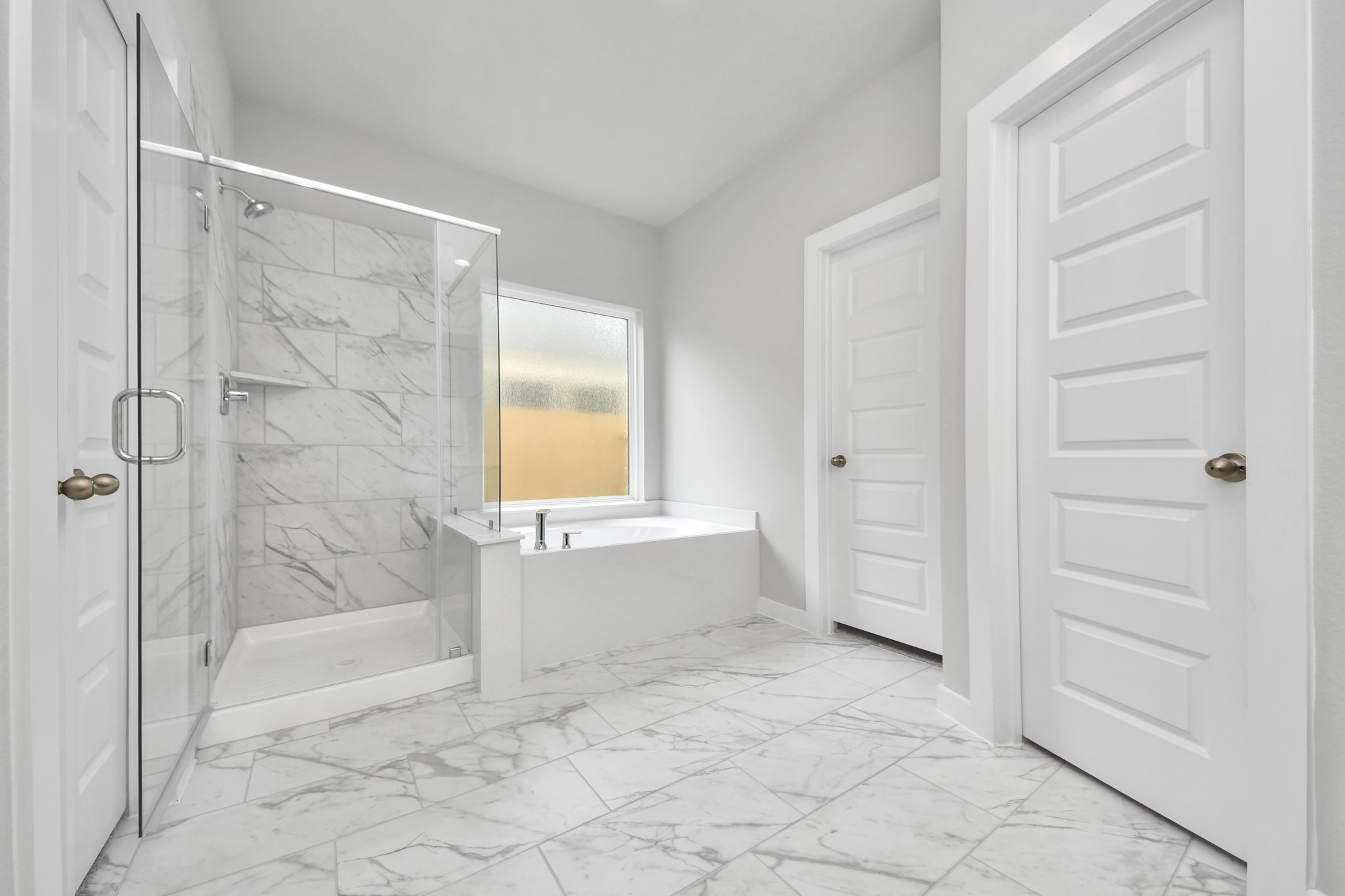 11106 Tulip Rdg Trail Houston, TX 77044 - Photo 20 of 34 Escape to a spa-like oasis in this primary bathroom. Enjoy a walk-in shower with tile surround, a separate garden tub with custom detailing, and an elegant vanity featuring light countertops, modern hardware, and beautiful vanity lights. Experience luxury and relaxation in every detail. Sample photo of completed home with similar floor plan. Actual colors and selections may vary.