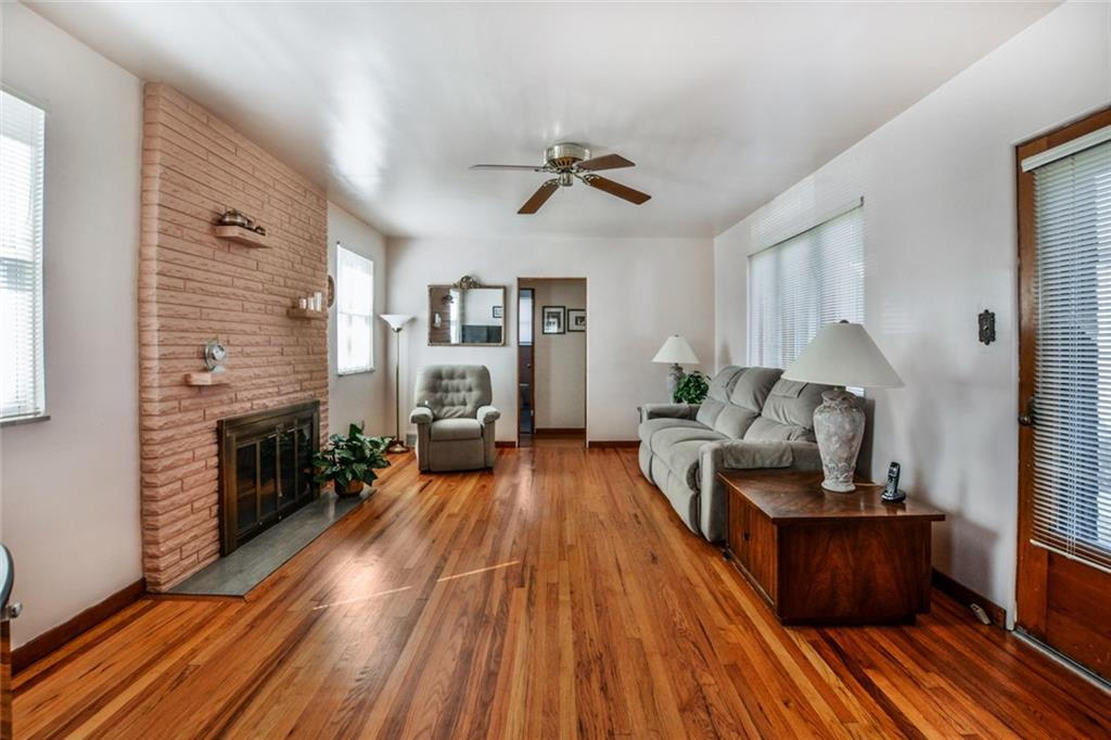 Large living space features beautiful hardwood floors, fireplace and a plethora of windows!