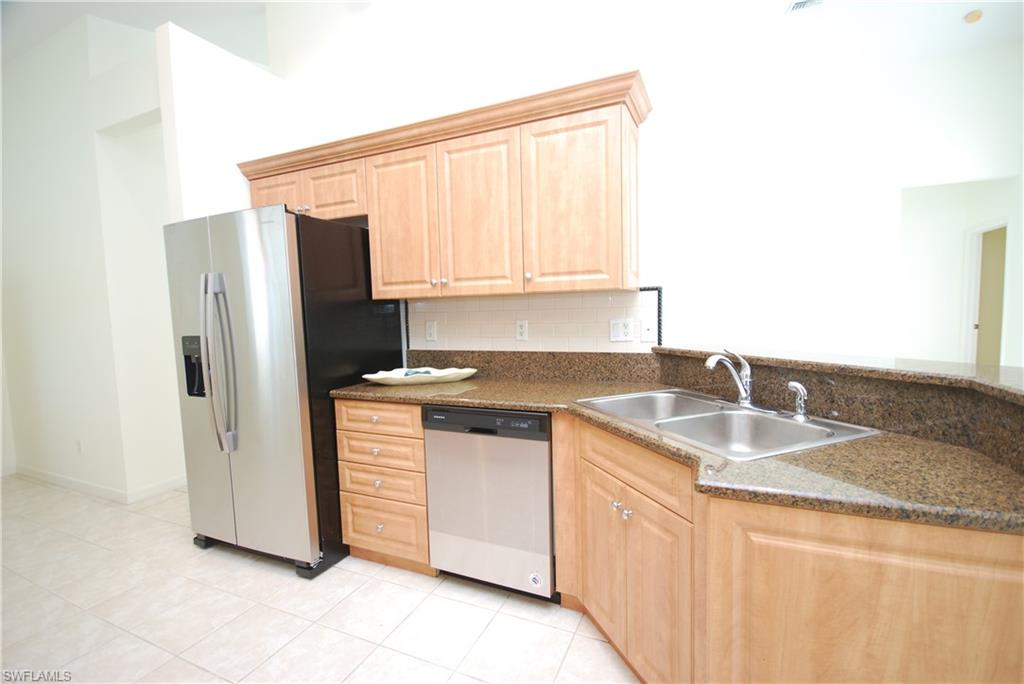 9200 Springview Loop Estero, FL 33928 - Photo 4 of 25 a kitchen with stainless steel appliances granite countertop a sink stove and refrigerator