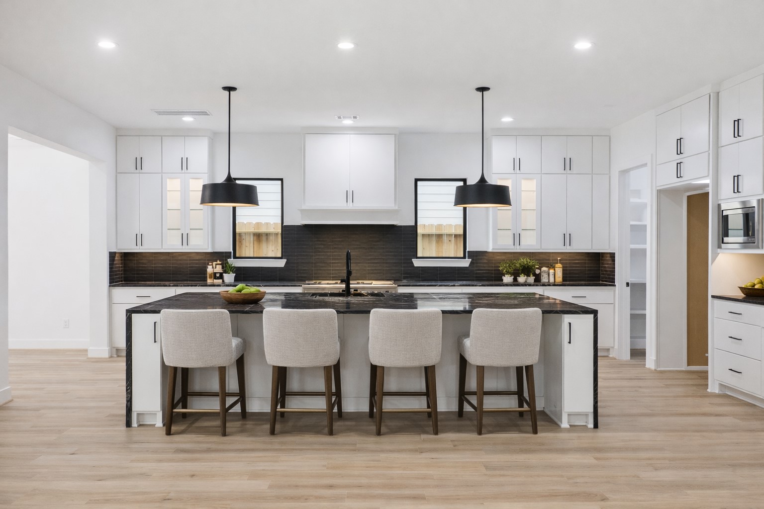 1201 Confederate Road Houston, TX 77055 - Photo 7 of 33 This designer kitchen makes a bold statement with its waterfall-edge island, black countertops, and contrasting pendant lights. Abundant cabinetry, dual windows, and a walk-in pantry offer both beauty and function, perfect for cooking, gathering, and entertaining. *Virtually Staged*