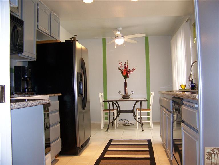 72400 Ridgecrest Lane Palm Desert, CA 92260 - Photo 7 of 25 a dining room with stainless steel appliances a dining table chairs and refrigerator