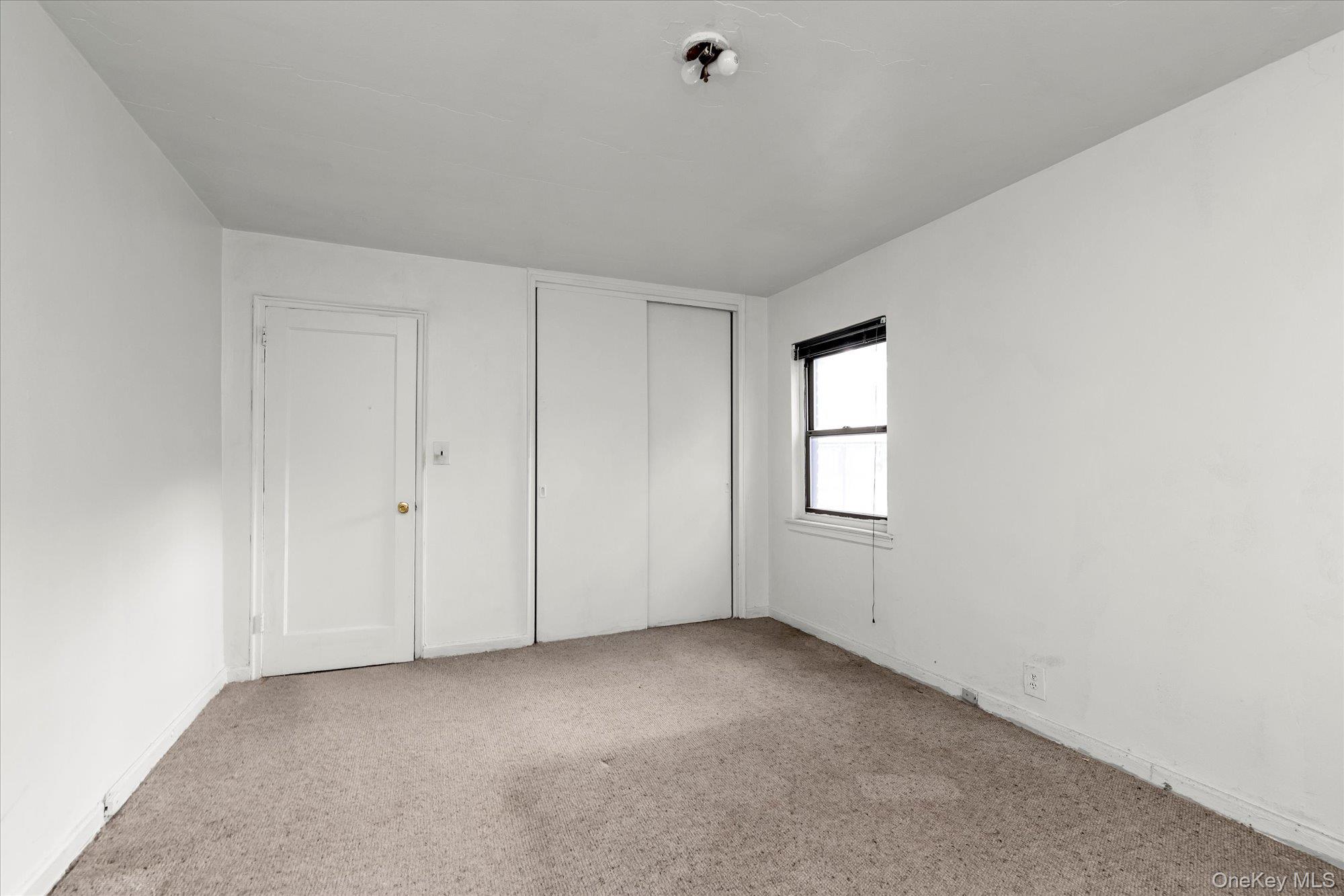 196-32 69th Avenue, Unit 1 Queens, NY 11365 - Photo 9 of 21 Unfurnished bedroom featuring carpet floors and a closet
