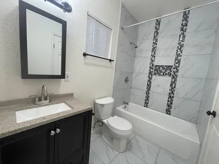 a bathroom with a toilet sink and mirror