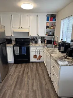 a kitchen with stainless steel appliances granite countertop a stove a sink and a refrigerator