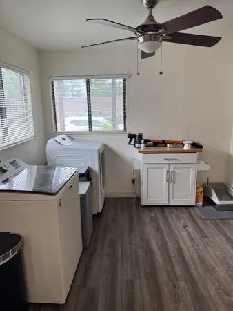 a kitchen with a stove a sink and wooden floor