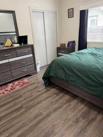 a bedroom with a bed and wooden floor