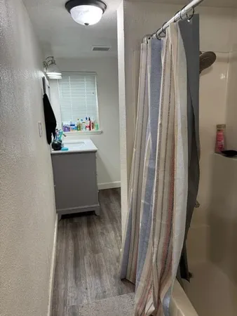 a bathroom with shower a mirror and a sink