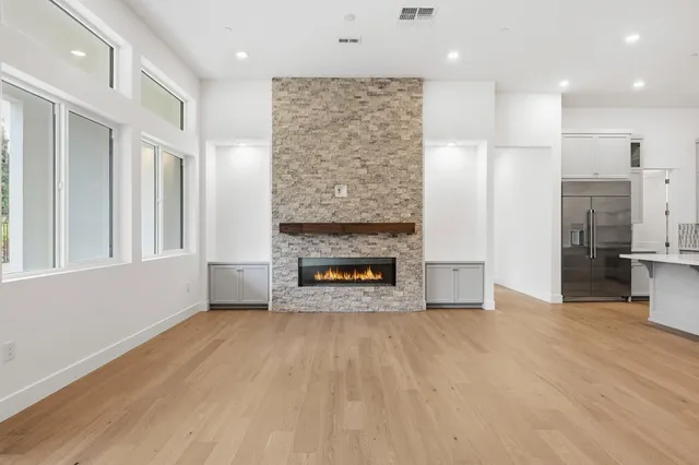 a view of an empty room with a fireplace and a window