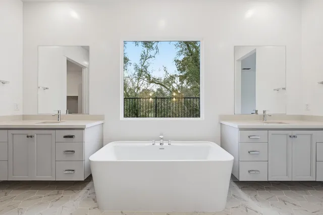 a spacious bathroom with double vanity sink a window and a mirror