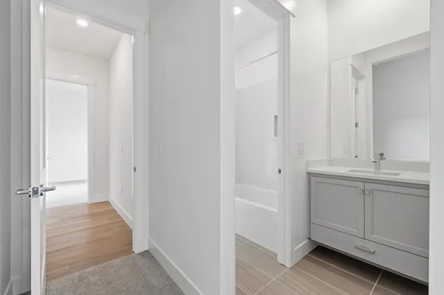 a bathroom with white cabinets and sink
