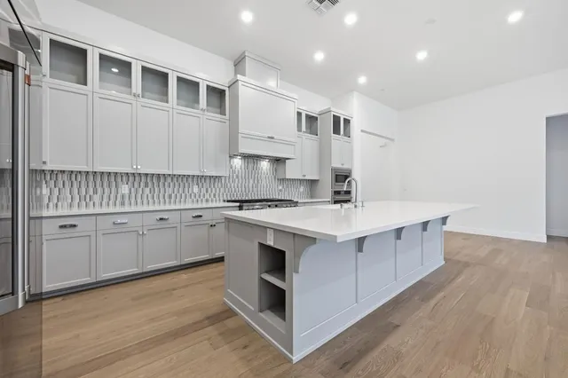 a kitchen with stainless steel appliances sink cabinets and wooden floor