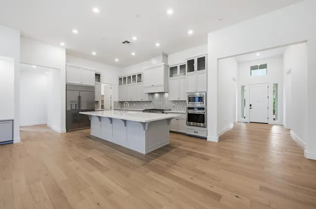 a large kitchen with stainless steel appliances granite countertop a large counter top and oven