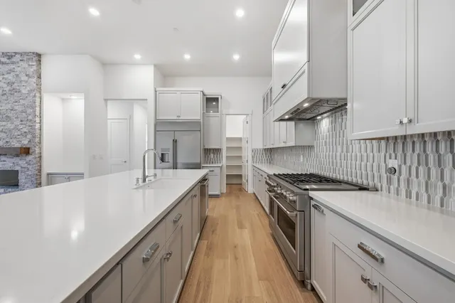 a large kitchen with stainless steel appliances granite countertop a lot of counter space and a sink