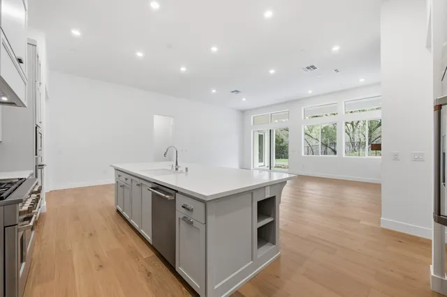 a kitchen with a sink and wooden floor