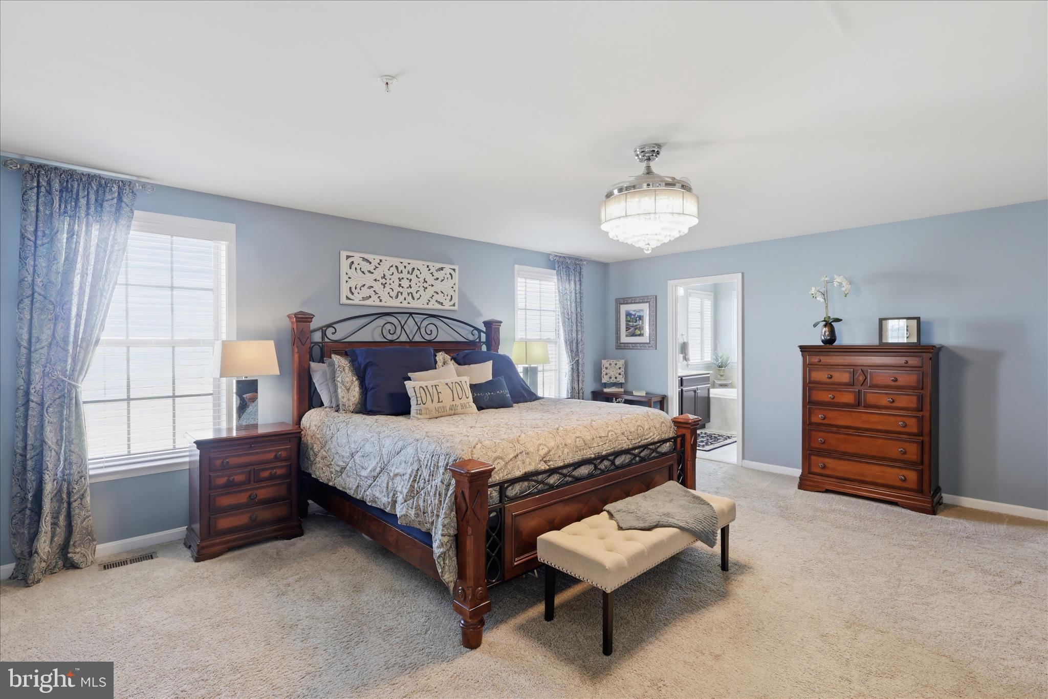 6606 Corbel Way Frederick, MD 21703 - Photo 24 of 60 a bedroom with a bed and a chandelier