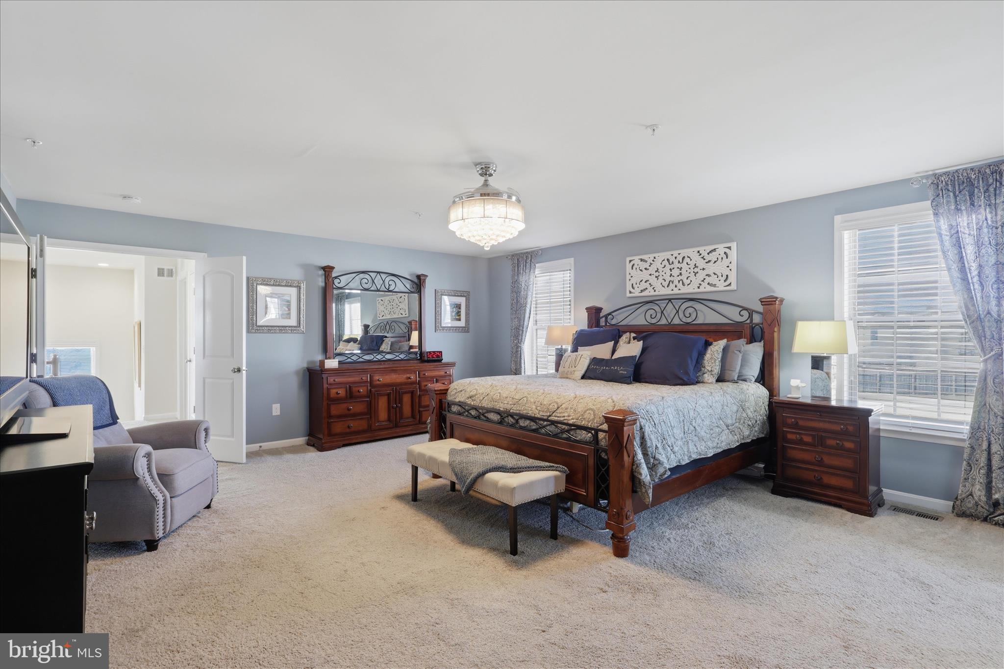 6606 Corbel Way Frederick, MD 21703 - Photo 26 of 60 a spacious bedroom with a bed and a chandelier
