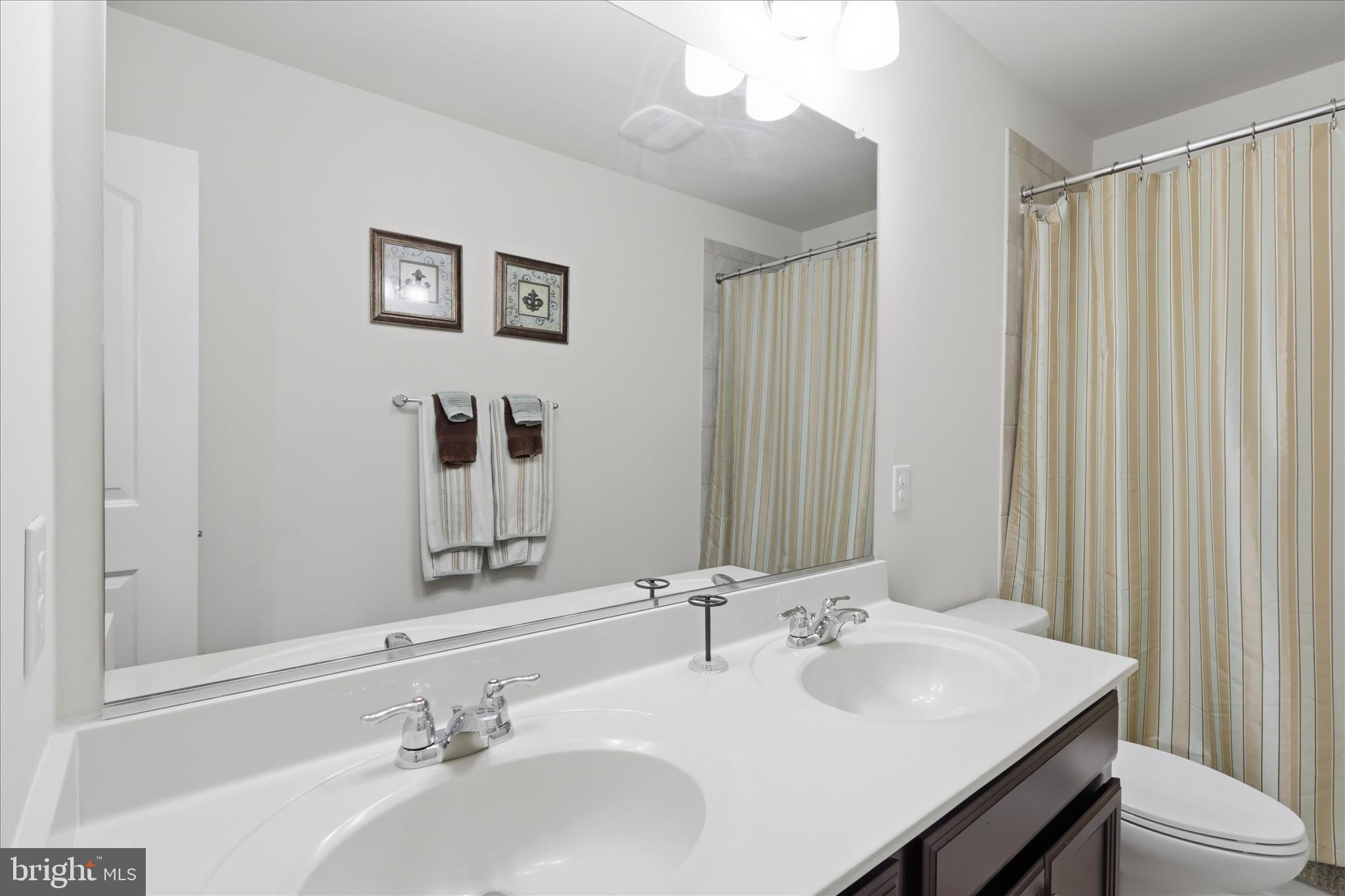 6606 Corbel Way Frederick, MD 21703 - Photo 32 of 60 a bathroom with a sink a toilet and mirror