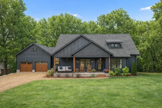 a front view of a house with yard and green space