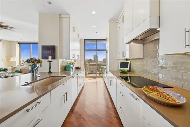 a large kitchen with stainless steel appliances granite countertop a lot of counter space and a sink