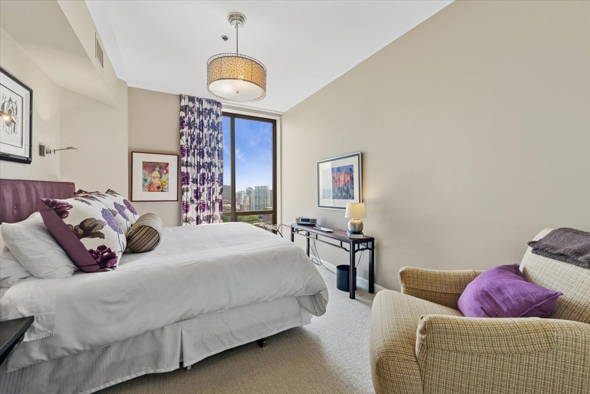 1335 South Prairie Avenue, Unit 2005 Chicago, IL 60605 - Photo 16 of 27 a bedroom with bed and a chandelier