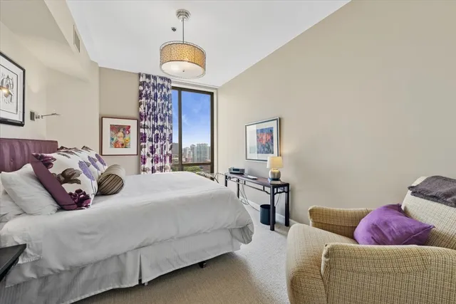 a bedroom with bed and a chandelier
