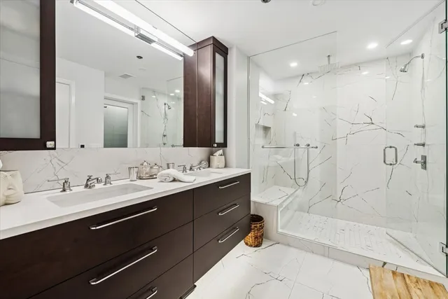 a bathroom with a double vanity sink mirror double and shower