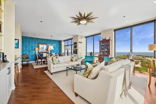 a living room with furniture a wooden floor and a chandelier