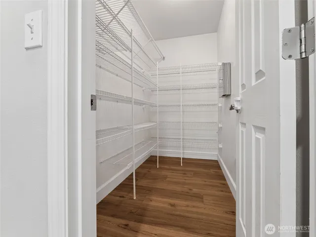 a view of a kitchen with wooden floor and white stainless steel appliances