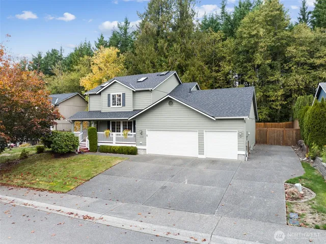 a aerial view of a house next to a yard and large trees