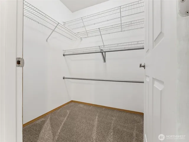 an empty room with windows and ceiling fan