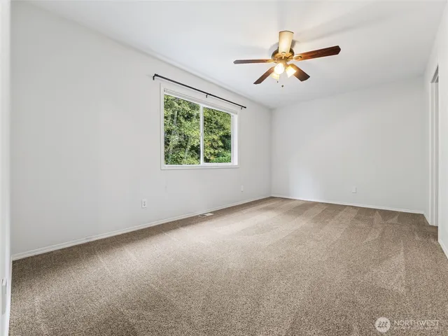 a view of an empty room with a ceiling fan