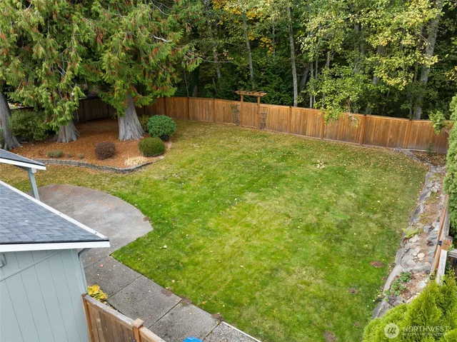 a view of a backyard with a small cabin and wooden fence