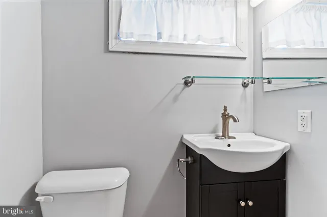 a bathroom with a sink a toilet and mirror