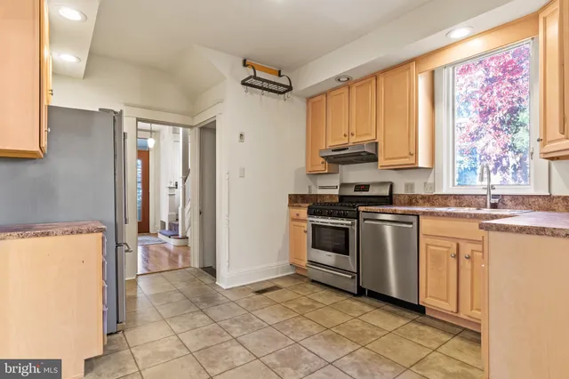 a kitchen with granite countertop a refrigerator and a stove top oven