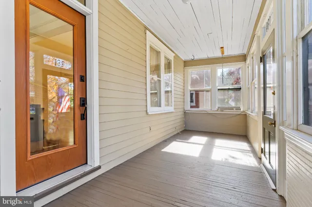 a view of a hallway with wooden floor and windows