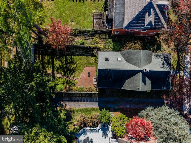 an aerial view of a house with a yard and large trees