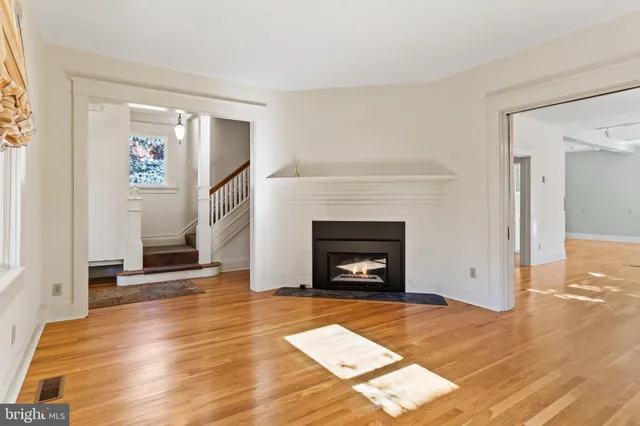 a view of empty room with wooden floor and fireplace