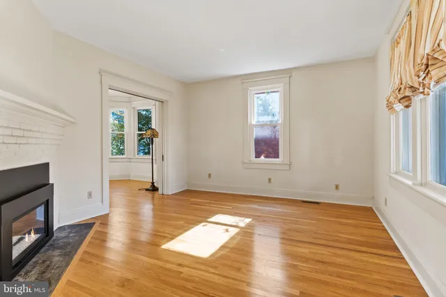 a view of empty room with wooden floor and fireplace