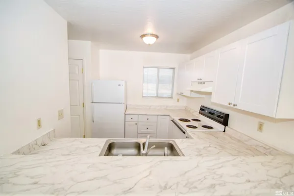 a kitchen with granite countertop a sink and a stove top oven