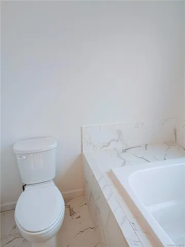a white toilet sitting next to a bathroom sink