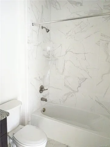 a white toilet and tub sitting next to a bathroom sink