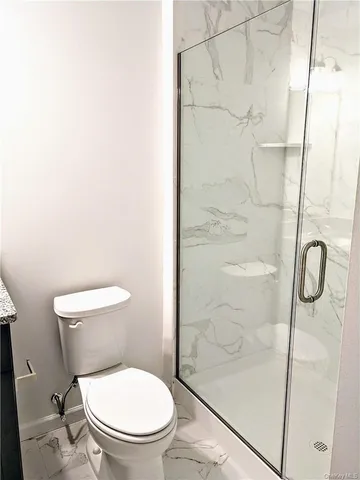 a bathroom with a granite countertop sink a toilet and a mirror