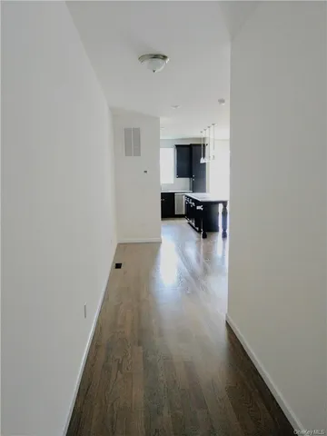 a view of empty room with wooden floor and window