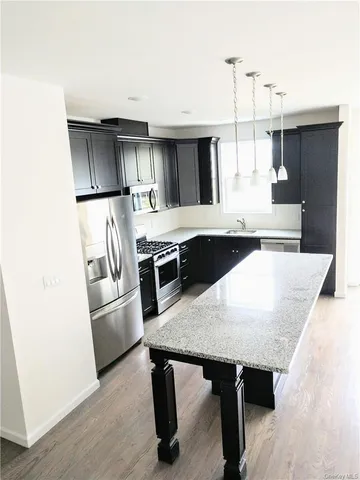 a kitchen with kitchen island a wooden floor and white cabinets