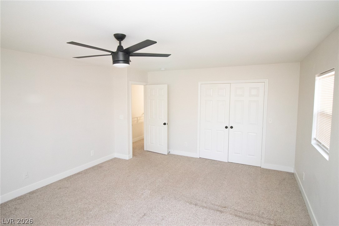 1468 Reef Ridge Court Las Vegas, NV 89128 - Photo 18 of 22 A spacious bedroom offers comfort with a practical ceiling fan and ample closet storage.