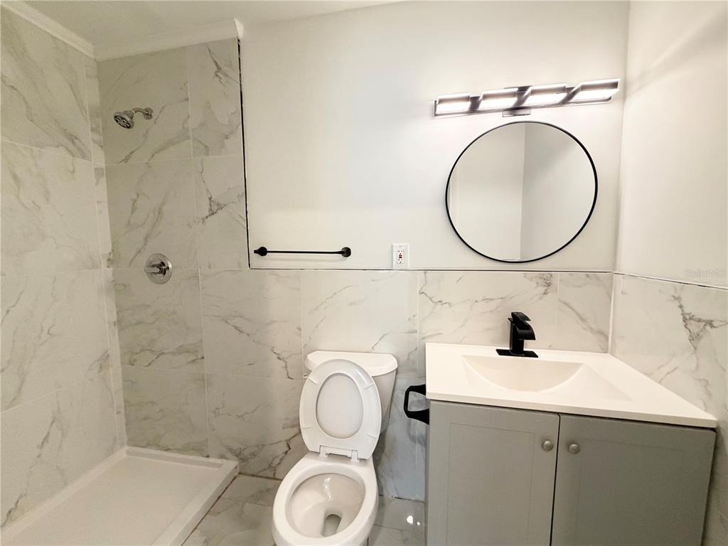 3207 Chariot Place Orlando, FL 32818 - Photo 11 of 21 a bathroom with a sink a toilet and a mirror