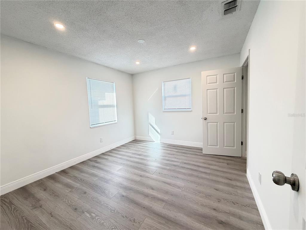 3207 Chariot Place Orlando, FL 32818 - Photo 12 of 21 an empty room with wooden floor and windows